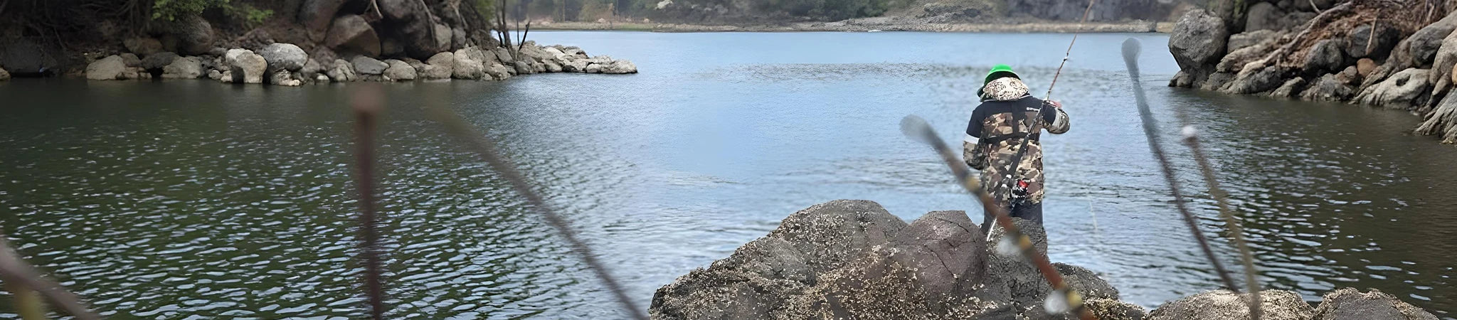 Fly angler casting from a rocky lake shore in New Zealand