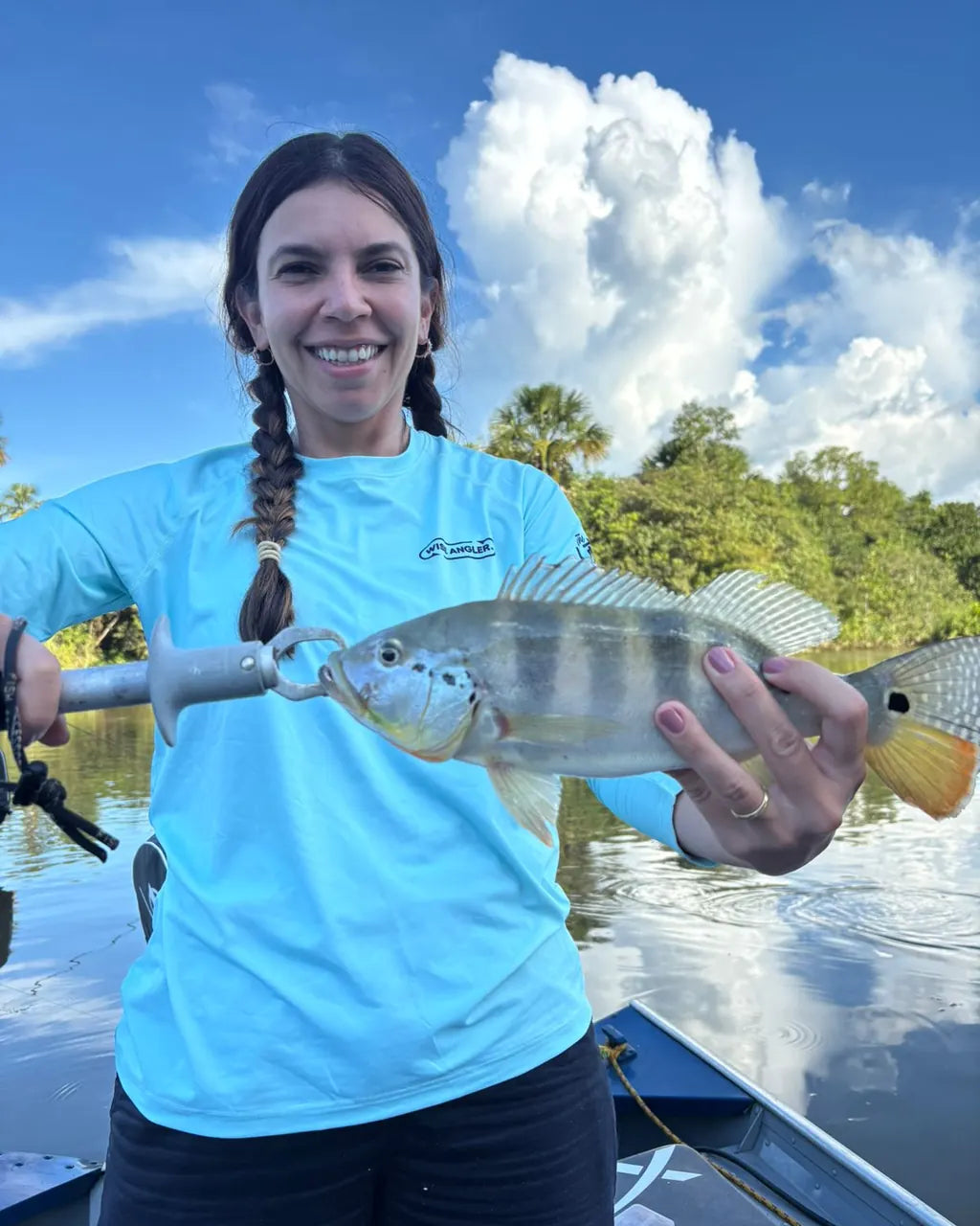 Angler holding her catch on the water